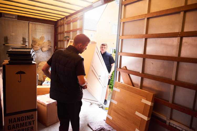 Flyttgubbar hjälps åt att packa lastbil